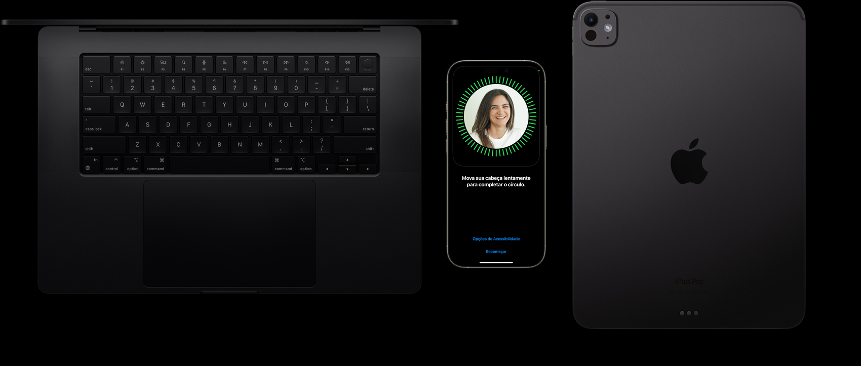 Um MacBook preto-espacial, um iPhone em titanio natural e um iPad preto-espacial, lado a lado, com o Face ID sendo configurado no iPhone