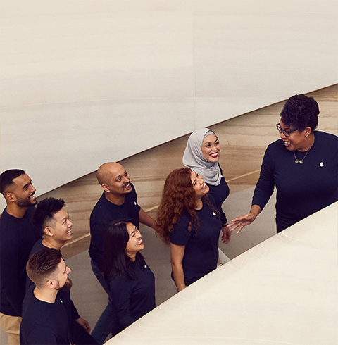 幾位團隊成員在 Apple Store 內(nèi)上樓梯。