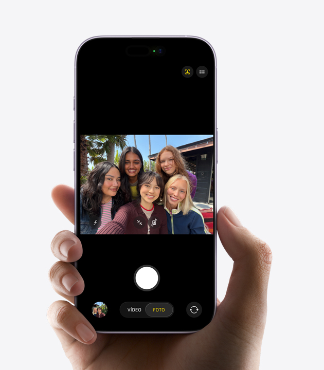 Parte frontal de un iPhone, en pantalla se está grabando un videoselfie de tres personas con la cámara frontal Center Stage, unos cuadrados amarillos que encierran los rostros de las personas muestran el encuadre automático