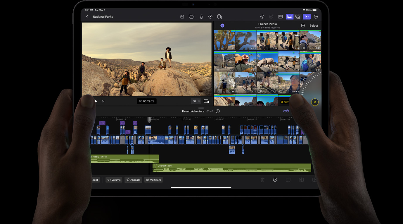 雙手拿著 iPad Pro，在 iPad 版 Final Cut Pro 上轉(zhuǎn)動(dòng) Jog Wheel 查看影片片段。
