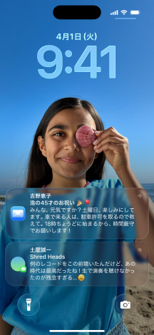 5つのiPhoneのモデル。各モデルが隣のモデルと少しずつ重なっている。左端の畫面にはメッセージアプリの背景を設(shè)定した會(huì)話、左から2番目の畫面にはカラフルなアプリのアイコンを表示したホーム畫面、中央のモデルには寫真、Liquid Glassでできた時(shí)刻を表す數(shù)字、畫面下部に2つの通知を表示したロック畫面、右から2番目のモデルにはクリアなLiquid Glassでできたアプリのアイコン、右端のモデルにはLiquid Glassのミュージックプレイヤーが映し出されている