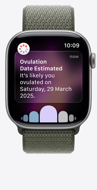 Apple?Watch Series?11，太空灰鋁金屬錶殼，展示透過健康?app 經(jīng)期追蹤收到的排卵日期推算通知、數(shù)碼錶冠，配搭森林色運(yùn)動(dòng)手環(huán)