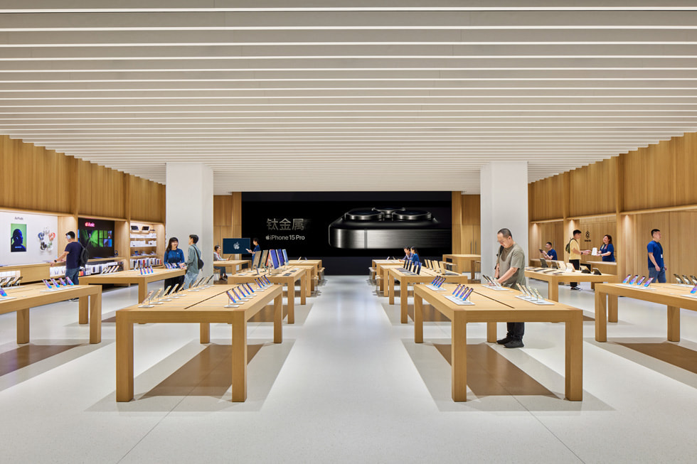 Integrantes del equipo conversan con clientes en el interior de Apple MixC Wenzhou.