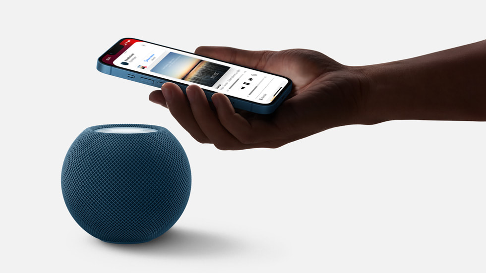 Bir kullan?c? iPhone’unu HomePod hoparl?rün üzerinde tutuyor.