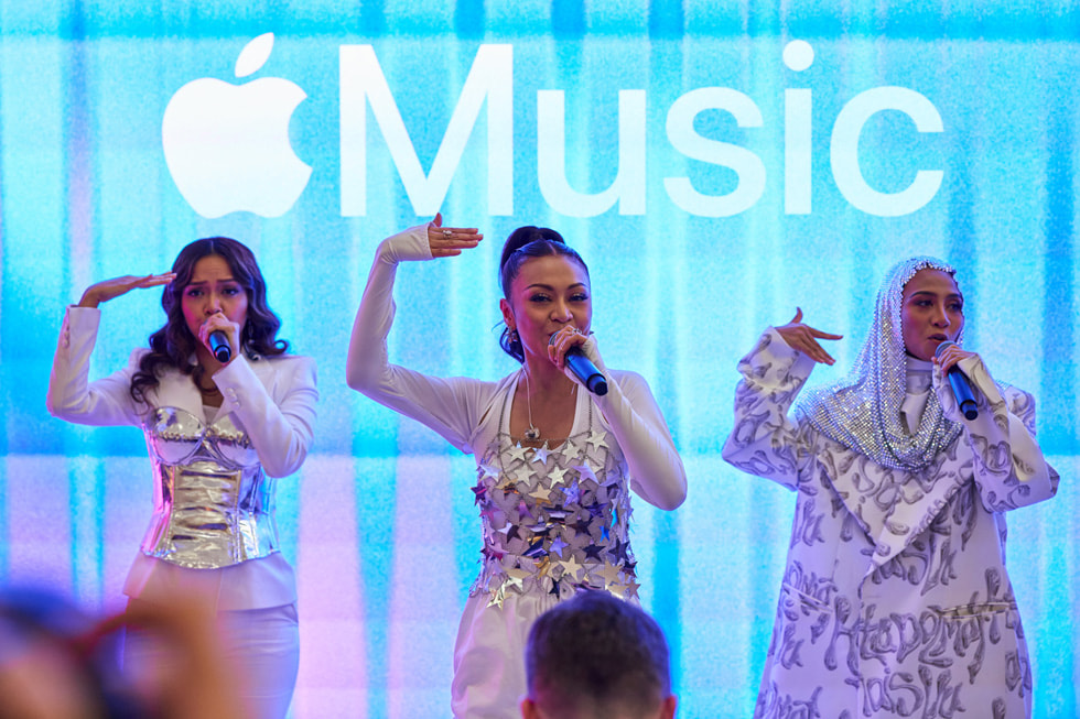 Tampak dekat dari pertunjukkan De Fam, dengan logo Apple Music di layar di belakang mereka.