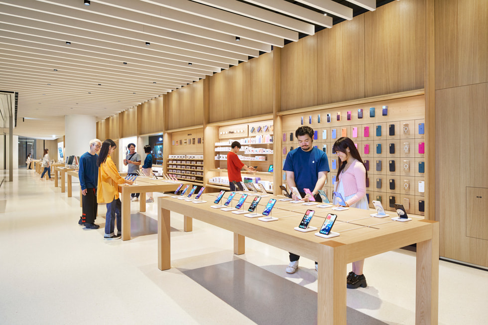 Apple 梅田の店內(nèi)にいるチームメンバーとお客様。