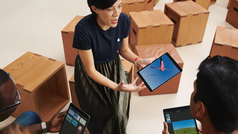 iPad kullanan bir Apple ekip üyesi ve iki mü?teri.