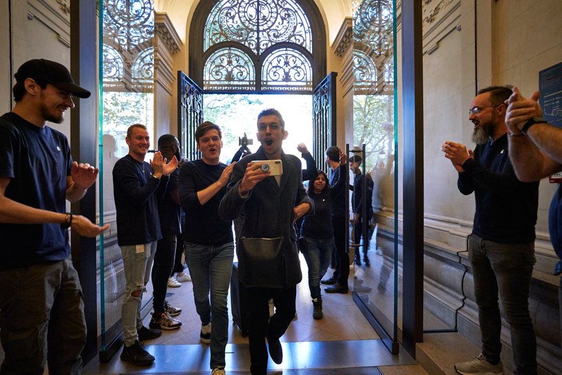 Apple team members greet customers entering Apple Champs-élysées.