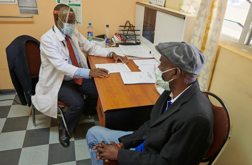 Zambiya’daki hastanenin klinik hekimi Samson Tembo hastas? Wilson Kalunga ile g?rü?me yap?yor.
