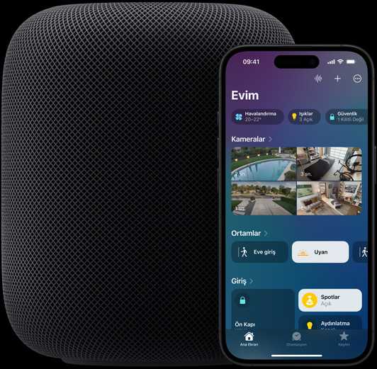 Ekran?nda, Ev uygulamas?n?n ana ekran?n?n g?rüldü?ü bir iPhone, bir HomePod hoparl?rün hafif?e ?nüne do?ru yerle?tirilmi? durumda