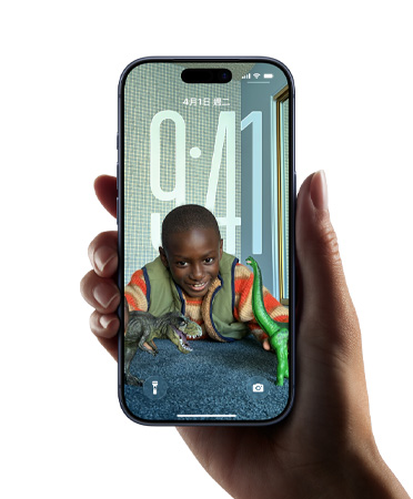 一隻手拿著 iPhone 裝置，展示全新 Liquid Glass 設(shè)計，讓時間顯示隨鎖定畫面上的影像動態(tài)調(diào)整