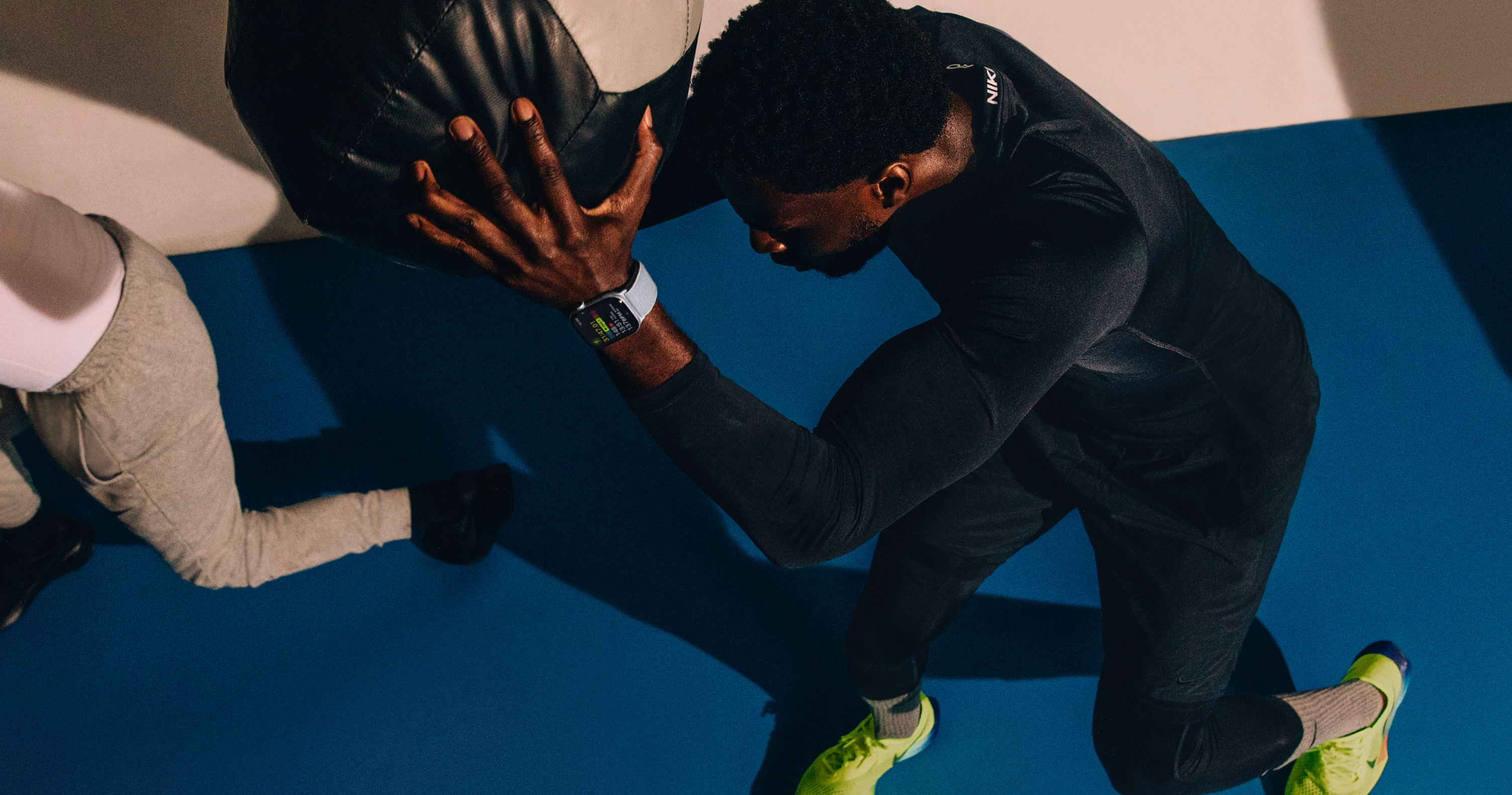 A man working out with a medicine ball while wearing Apple?Watch Series?10.