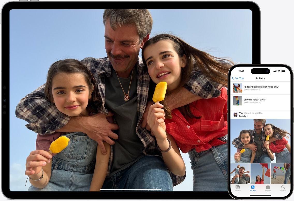 Ekrany iPada i?iPhone’a przedstawiaj?ce Zdj?cia w?iCloud z?fotografiami ojca i?jego dwóch córek na pla?y