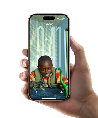 Une main tenant un iPhone affichant le nouveau design Liquid Glass qui permet à l’heure de s’adapter automatiquement à l’image sur l’écran verrouillé